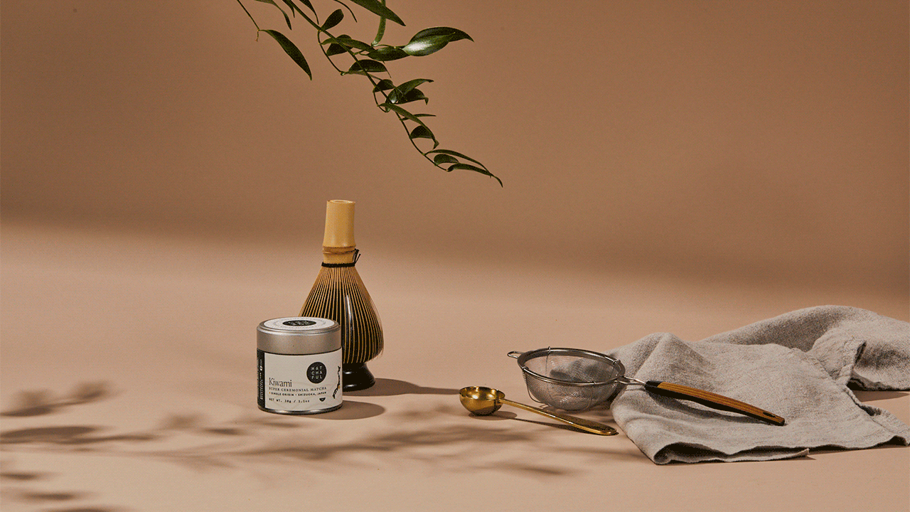 Gif of hand setting down whisking bowl in a mise en place of everything needed to make matcha