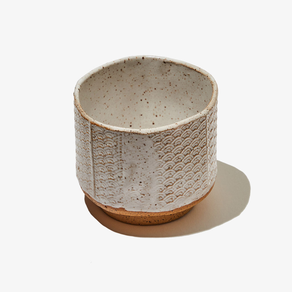 White glazed ceramic matcha tea bowl with a Seigaiha pattern on the exterior
